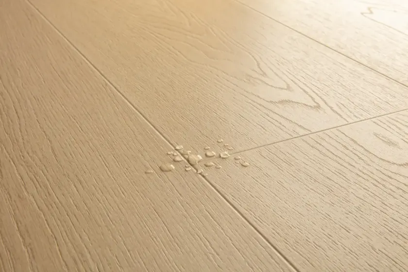 Water droplets resting on a Pergo floor surface