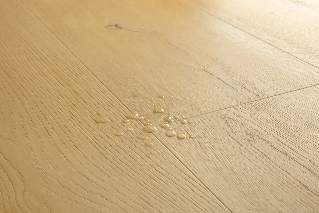 Water droplets resting on the surface of a Pergo laminate plank